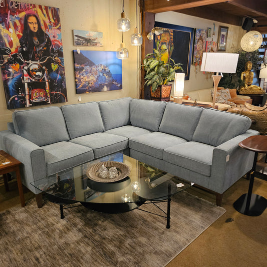 Gray sectional sofa in a living room with decorative items on the coffee table.
