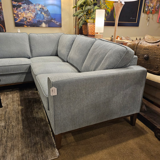 Gray sectional sofa in a living room setting with decor elements.