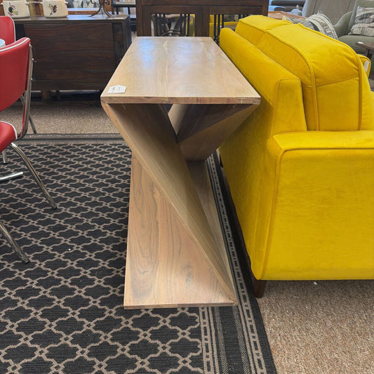 Wooden table with a yellow couch and red chairs in a room setting.