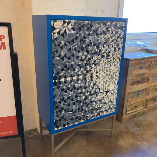 Cabinet with geometric patterned door in a room setting