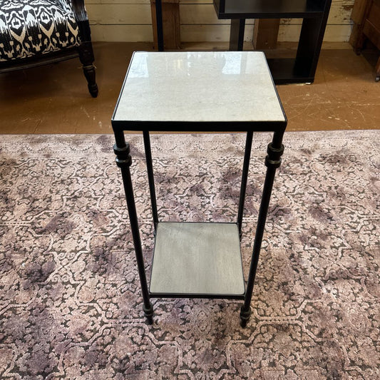 Small black metal table with a glass top on a patterned rug