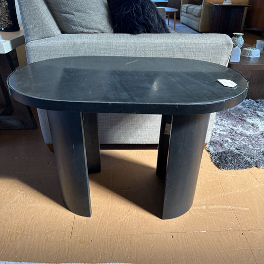 Black marble coffee table in a living room setting with furniture and decor.