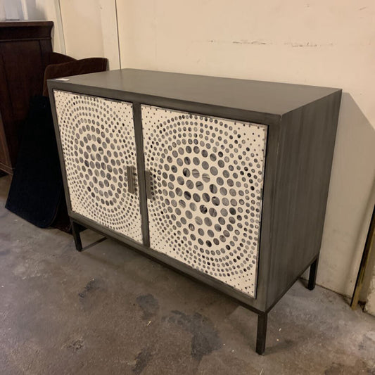 Cabinet with decorative circular pattern on doors in a room setting