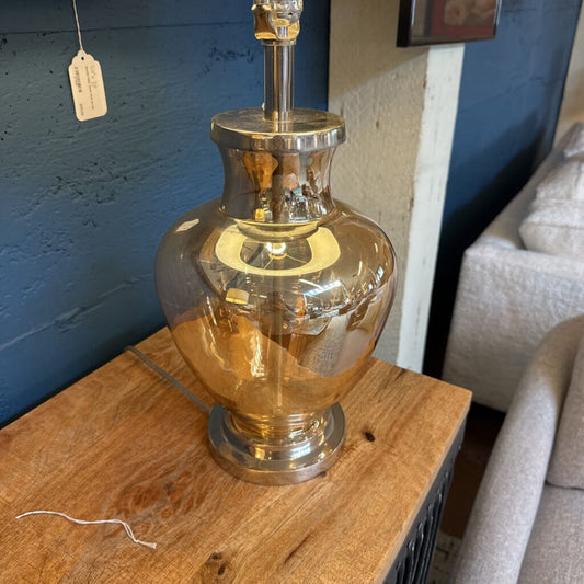 Glass lamp on a wooden surface with a blue wall in the background
