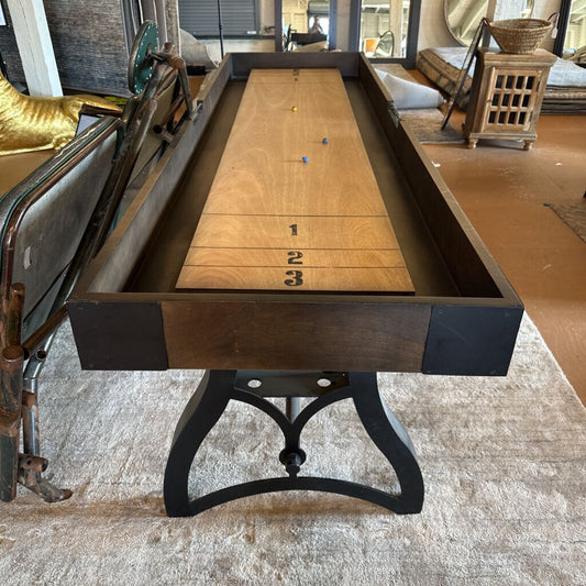Wooden shuffleboard table with metal frame in a room setting