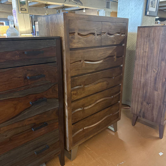 Wooden dresser with wavy grain pattern in a store setting