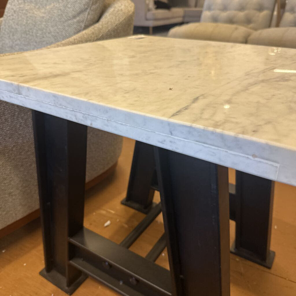 Table with marble-like top and metal legs in a room setting