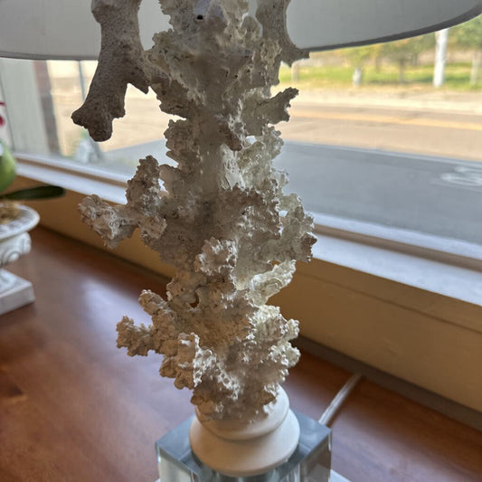 Decorative coral sculpture on a stand in front of a window