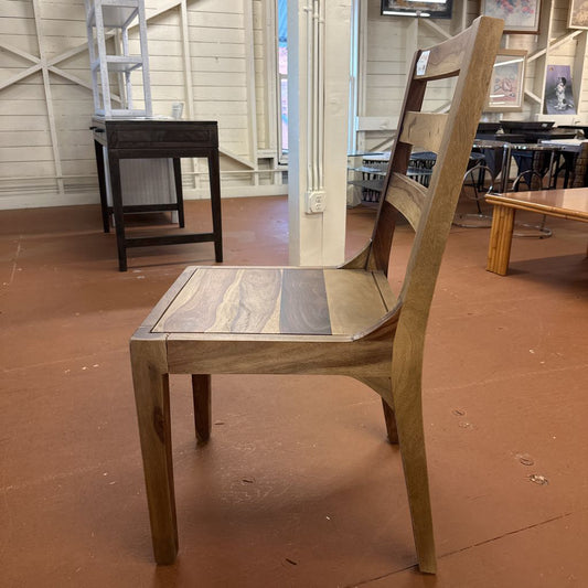 Wooden chair with a unique seat design on a brown floor.