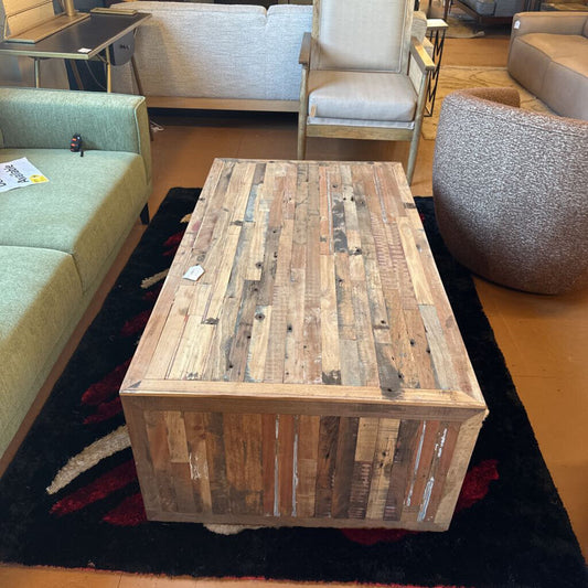 Wooden coffee table in a living room setting with furniture and decor.