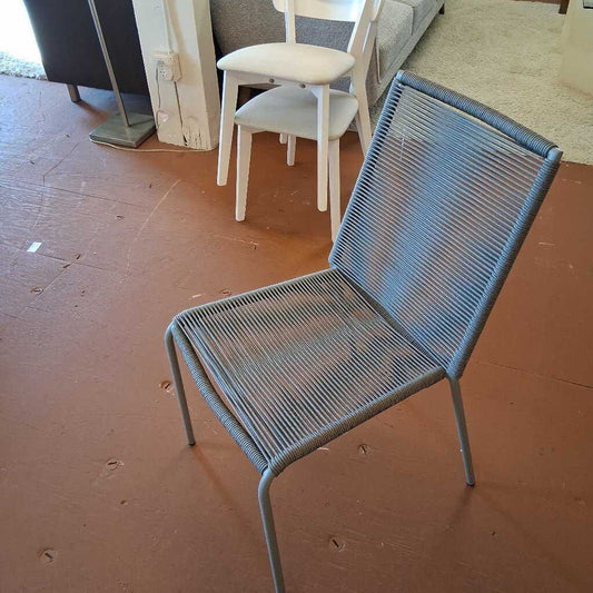 Blue metal chair on a brown floor with other chairs in the background