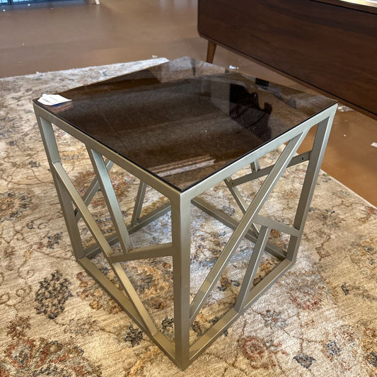 Small side table with glass top and metal frame on a patterned rug