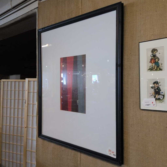 Framed artwork on a wall with a traditional Japanese sliding door in the background