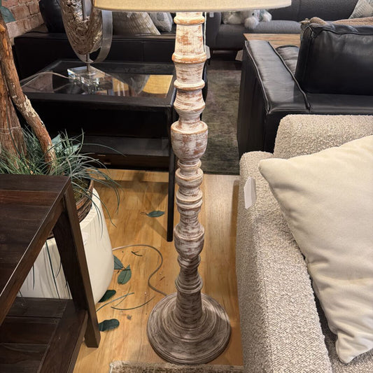 Decorative floor lamp in a living room setting with furniture and decor.