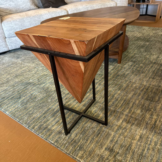 Wooden side table with black metal legs in a living room setting