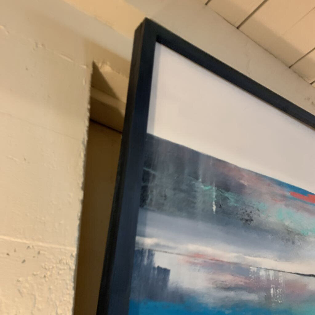 Framed abstract painting leaning against a wall