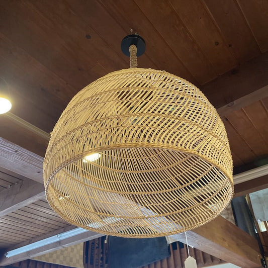 Woven rattan pendant light hanging from a wooden ceiling