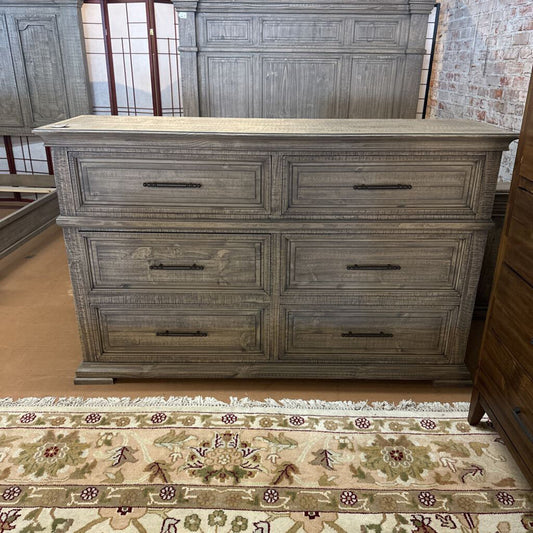 Wooden dresser with multiple drawers on a patterned rug