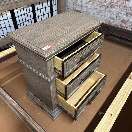 Wooden dresser with open drawers on a wooden floor.