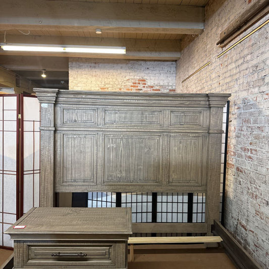 Large wooden cabinet in a room with brick walls and a window.