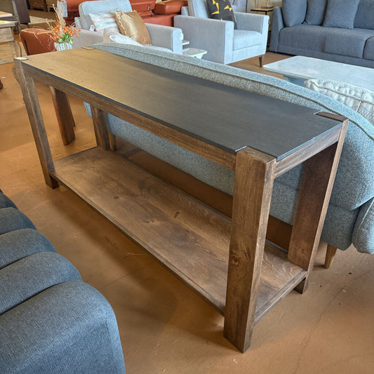 Wooden console table with a gray top in a showroom setting