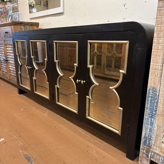 Black cabinet with glass doors on a brown floor