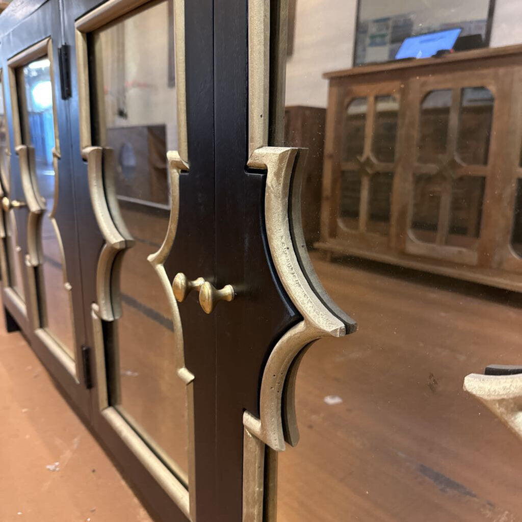 Close-up of a wooden cabinet with glass doors and decorative handles.