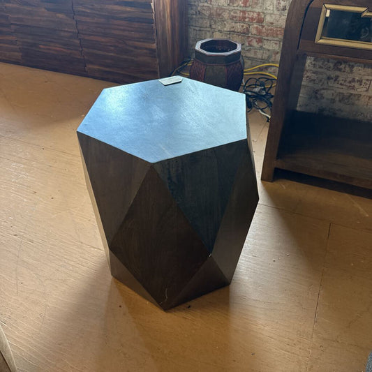 Hexagonal wooden block on a wooden floor with a rustic background