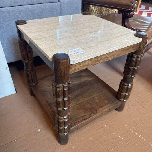 Wooden side table with marble top on a cardboard surface