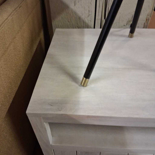 Black umbrella with gold tip on a white surface