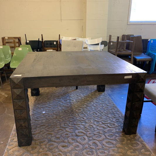 Large dark wooden table in a room with chairs and a patterned rug