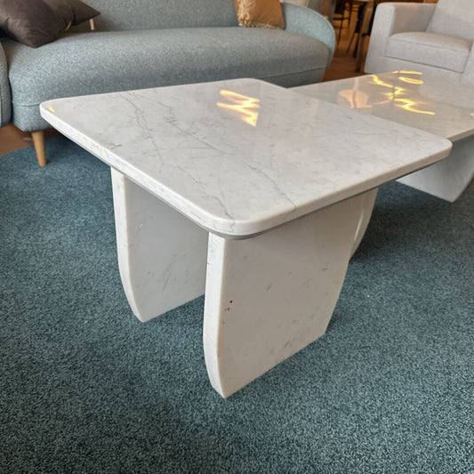 Marble coffee table in a living room setting with a sofa and chairs.