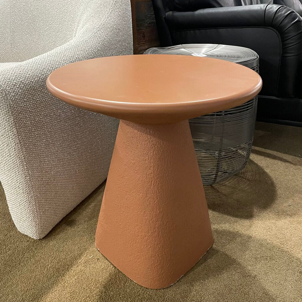 Round side table with a cylindrical base in a living room setting