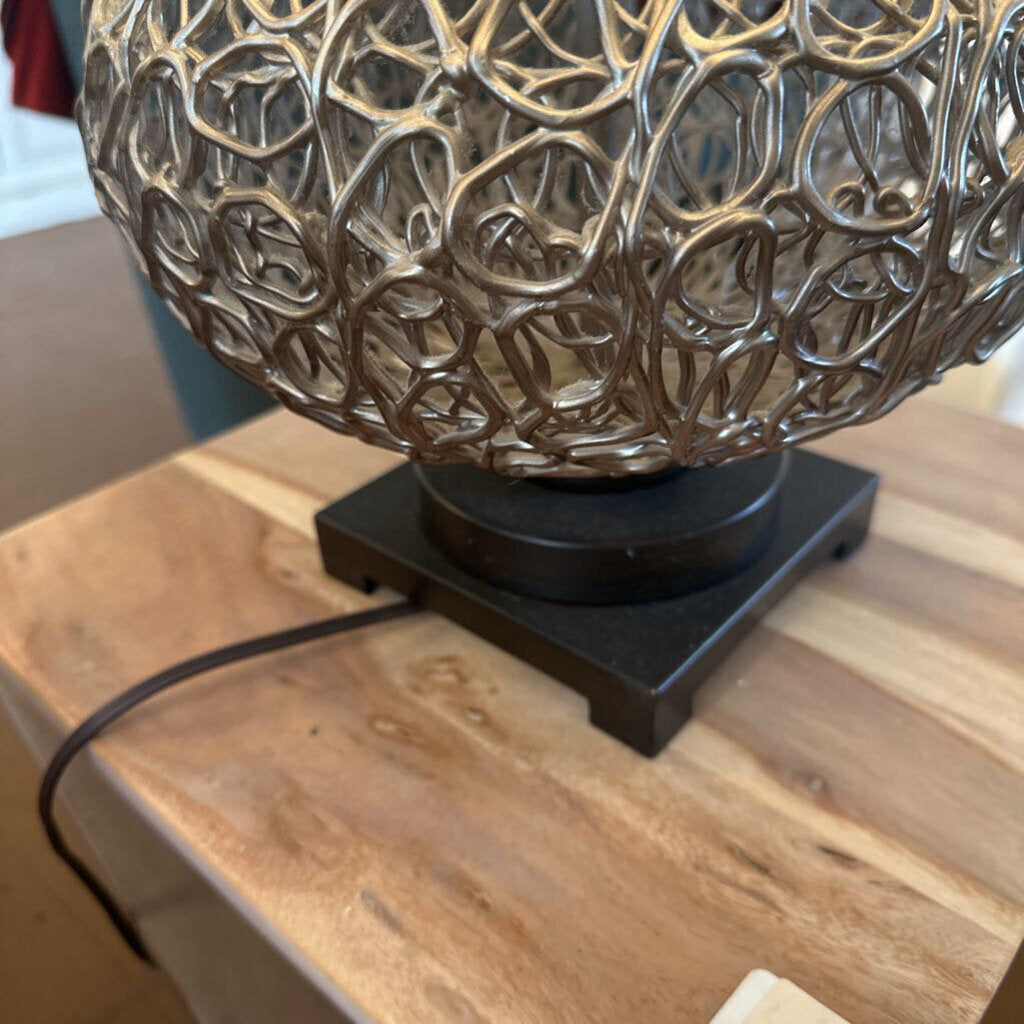 Decorative lamp with intricate design on a wooden surface