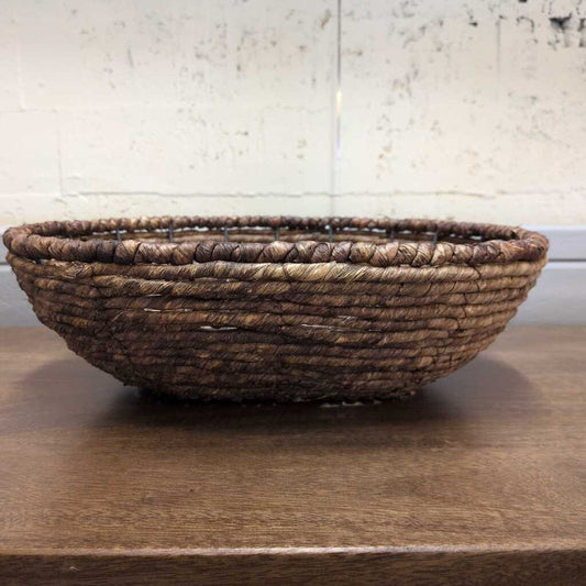 Woven basket on a wooden surface with a neutral background