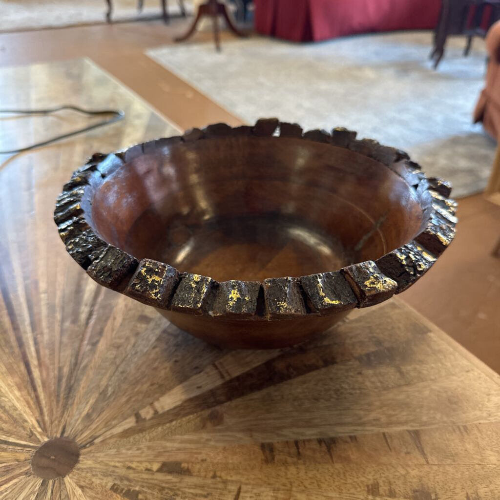 Wooden bowl with decorative edge on a wooden table