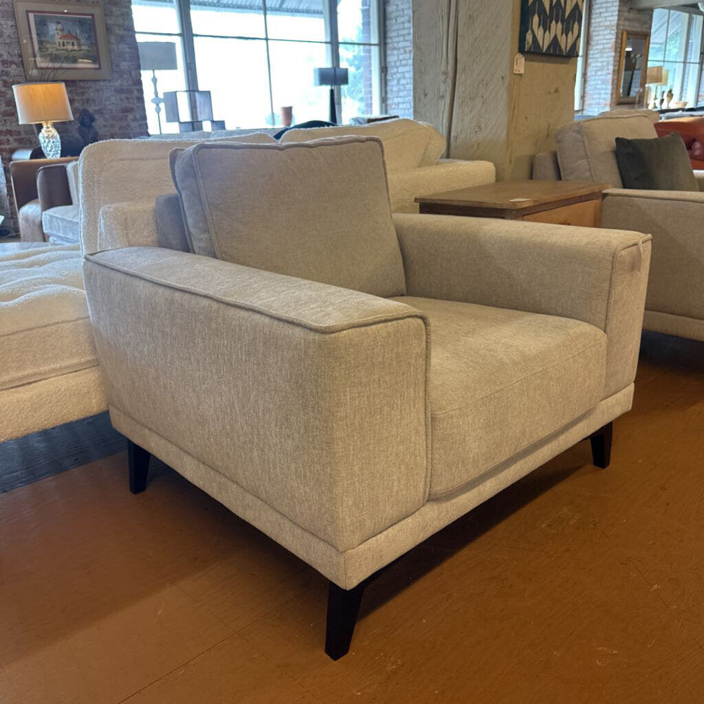 Beige armchair in a room with other furniture