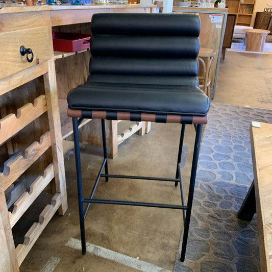 Black bar stool with brown accents in a store setting