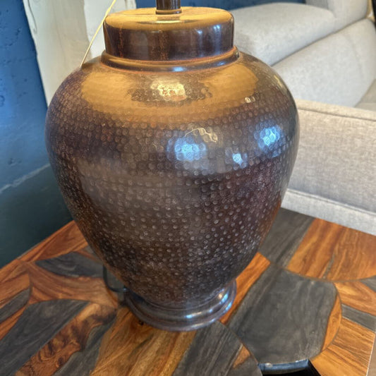 Decorative brown vase on a wooden table with a blurred background