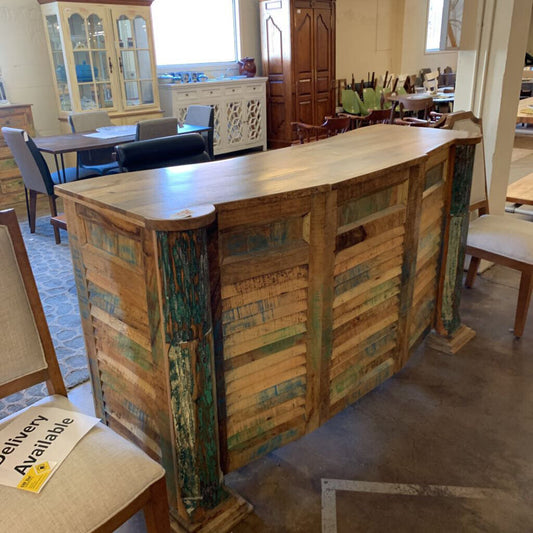 Wooden reception desk in a room with chairs and tables