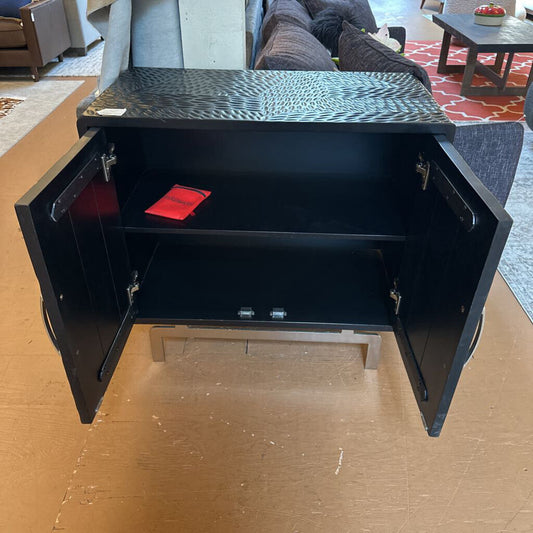 Black metal cabinet with open door on a wooden floor