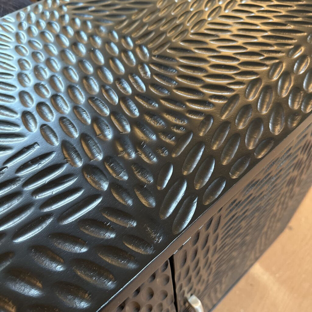 Close-up of a textured metal surface with a wavy pattern