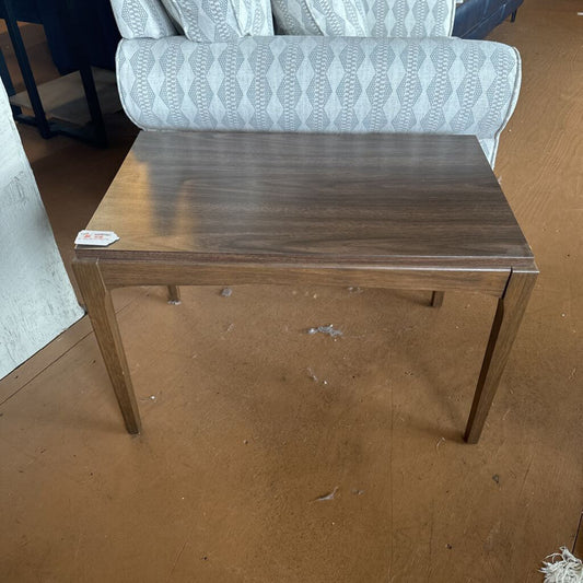 Wooden table with a price tag on a brown floor