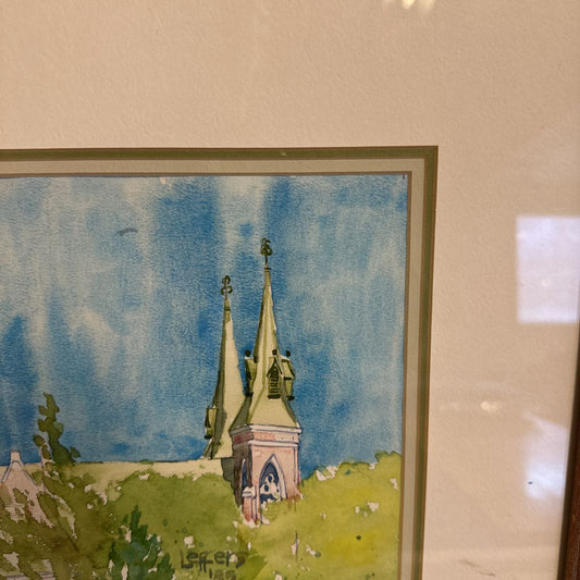 Framed watercolor painting of a church with a steeple against a blue sky.