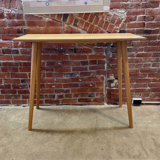 Wooden table against a brick wall
