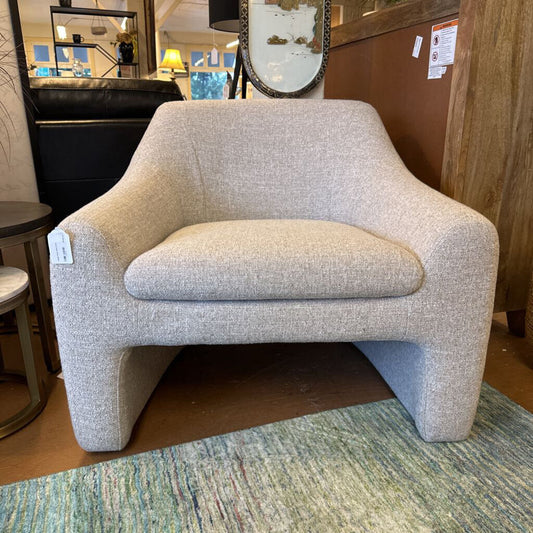 Gray armchair in a room with mirrors and a rug