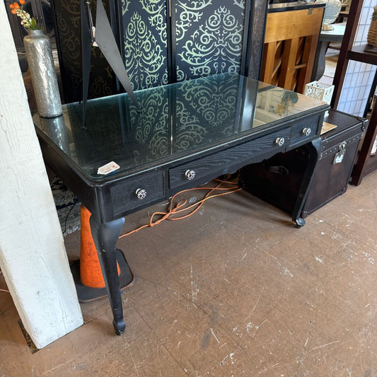 Black vanity table with mirror in a room setting