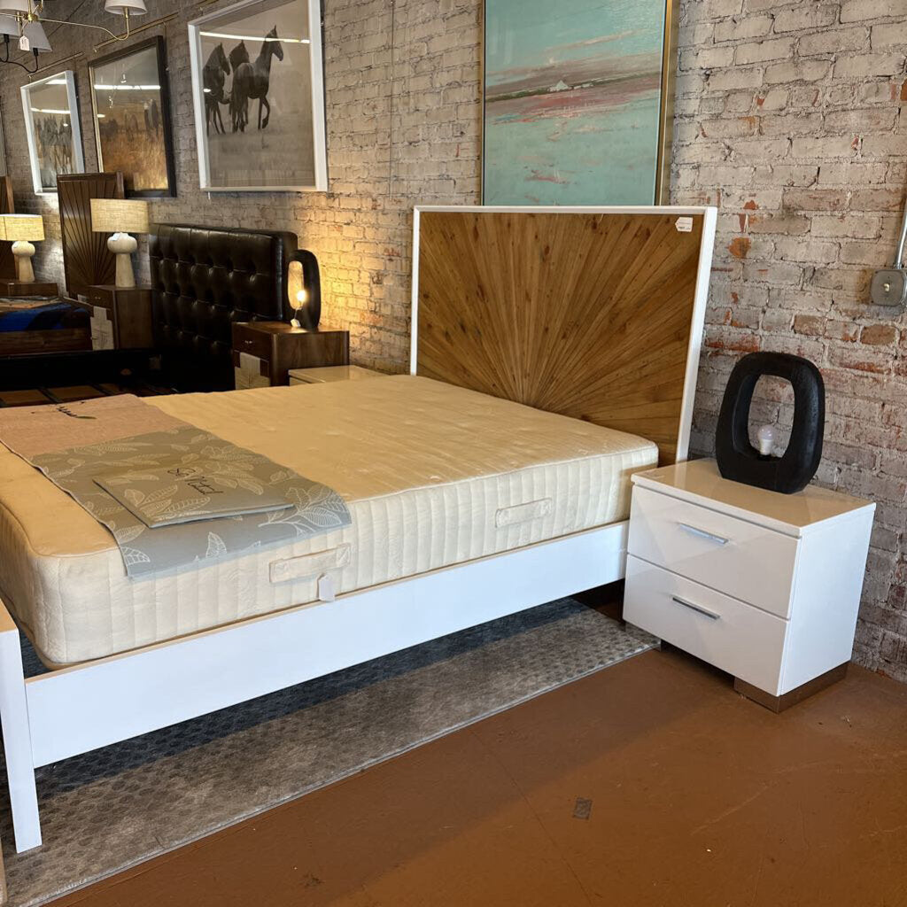 Bedroom with a bed, nightstand, and artwork on a brick wall.