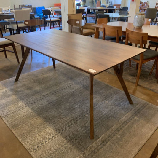 Wooden dining table in a room with chairs and tables