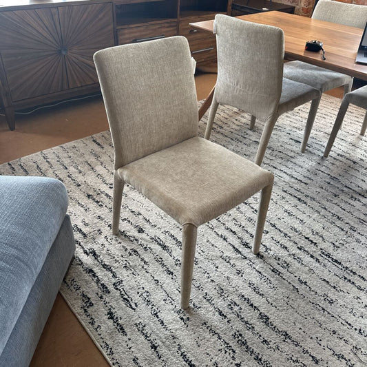 Beige chair on a patterned rug in a room with furniture